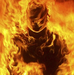 A shoulders-up portrait of a burning man.